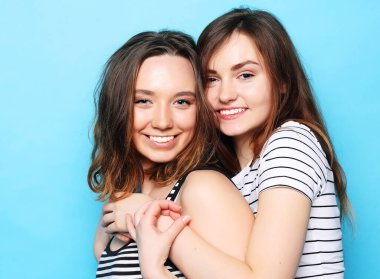 İki güzel genç kız arkadaş gülümsüyor ve eğleniyorlar.