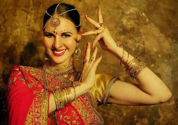 Ritratto sorridente di bella ragazza indiana a casa. Modello giovane donna con set di gioielli dorati . — Foto Stock