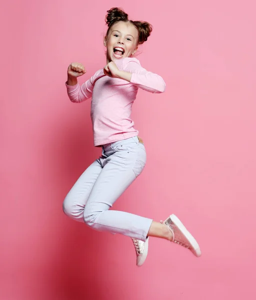 Divertente bambino ragazza vestito casual salto su sfondo rosa — Foto Stock