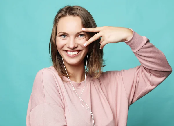 Portrait of gorgeous woman looking at camera with smile and showing peace sign with fingers — Stock Photo, Image