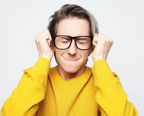 Várom a különleges pillanatot. Sárga pulóvert és szemüveget viselő fiatalember portréja — Stock Fotó