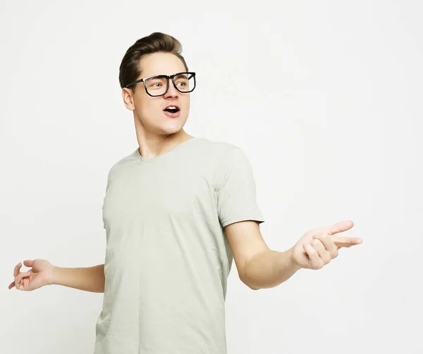 Feliz joven guapo hombre haciendo gestos y manteniendo la boca — Foto de Stock