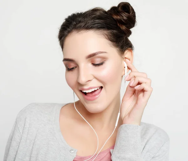 Mooie jonge vrouw in koptelefoon luisteren naar muziek — Stockfoto