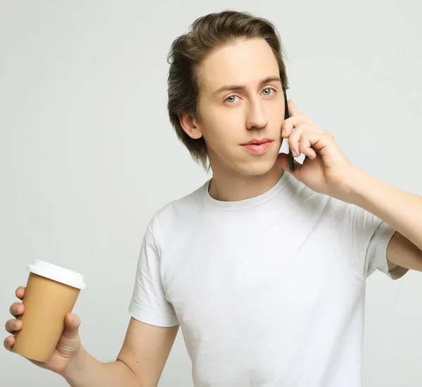 Portret van een gelukkige man die telefoneert en koffie drinkt — Stockfoto