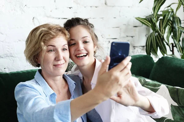 成熟的母亲和女儿用智能手机和生活方式的概念自拍 — 图库照片