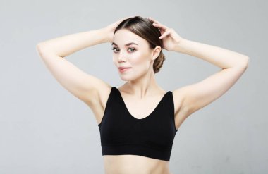 Gri arkaplanda tertemiz bir cilde sahip güzel bir genç kadın.