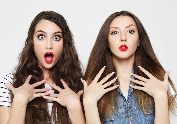 Two young girl friends having fun. Both making surprised faces. — Stock Photo, Image