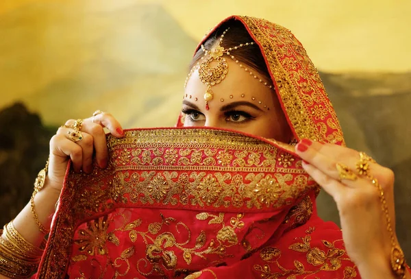 Porträtt leende av vacker indiansk flicka hemma. ung kvinna modell med gyllene smycken set . — Stockfoto
