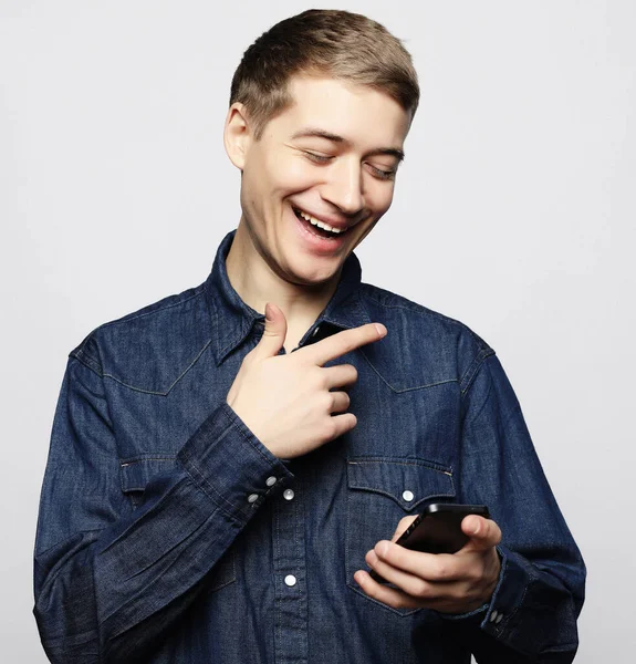 Glad ung man i glasögon skriva sms på vit bakgrund — Stockfoto