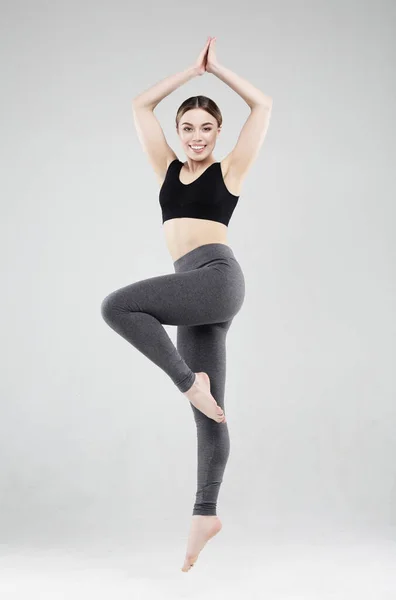 Passform och frisk kvinna. Glad fitness kvinna i sportkläder hoppar över vit studio bakgrund. — Stockfoto