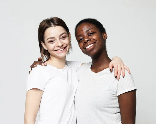 Retrato de mulheres multirraciais jovens de pé juntos e sorrindo para a câmera isolada sobre fundo branco — Fotografia de Stock