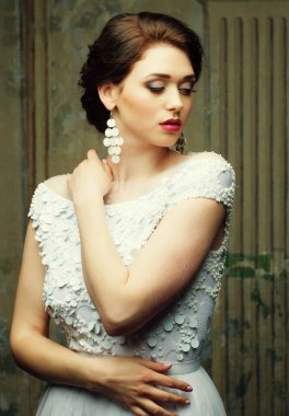 Beyaz elbiseli ve küpeli güzel genç gelin, güzellik ve gençlik, mutluluk ve masumiyet