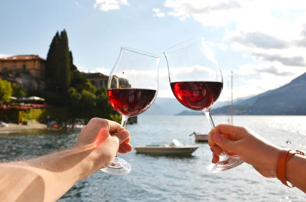Gafas de vino en las manos contra el lago —  Fotos de Stock