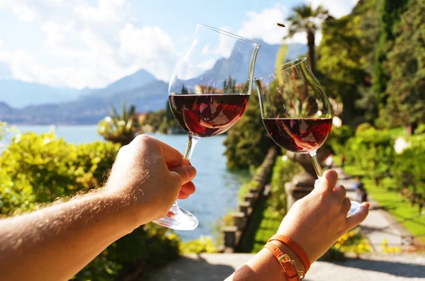 Gafas de vino en las manos contra el lago — Foto de Stock