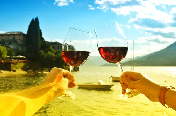 Verres à vin dans les mains contre le lac — Photo