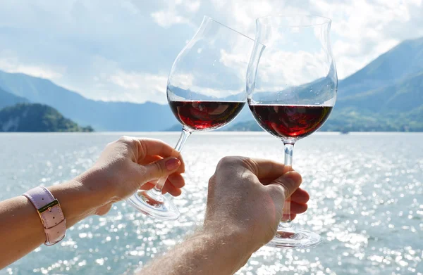Gafas de vino en las manos contra el lago — Foto de Stock