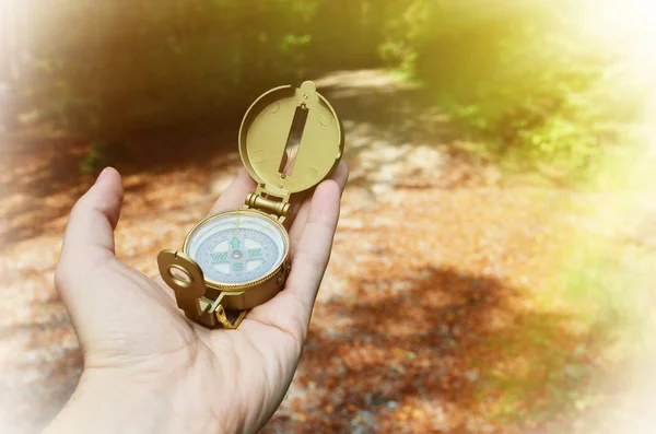 Male hand holding compass on nature — Stock Photo, Image