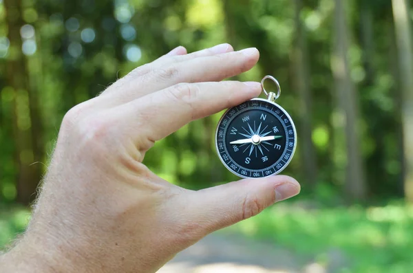 Male hand holding compass on nature — Stock Photo, Image