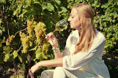 Üzüm bağları arasında beyaz şarap tatma kız. 