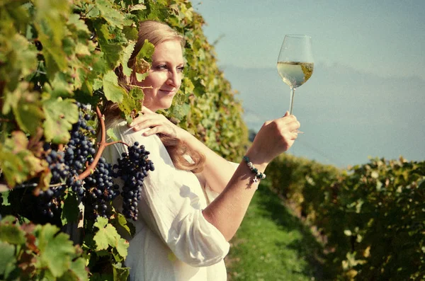Mädchen verkostet Weißwein inmitten von Weinbergen. — Stockfoto