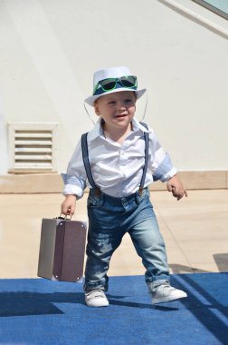 Bavullu küçük çocuk.