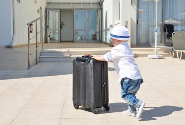  Bavullu küçük çocuk.