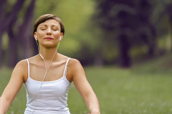 Mujer escuchando música con los ojos cerrados . — Foto de Stock