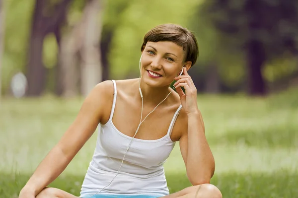 Zrelaksowany kobieta słuchania muzyki uśmiechający się. — Zdjęcie stockowe
