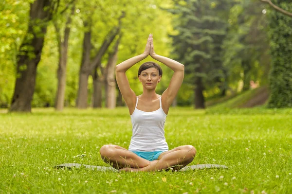 Vrouw mediteren en yoga in park doen — Stockfoto