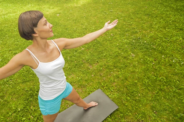 Kvinna som gör yoga i parken — Stockfoto