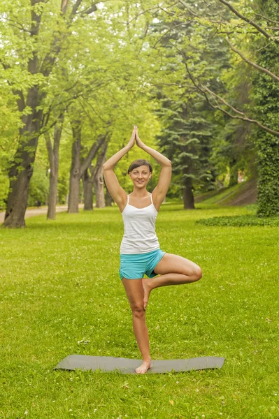 Mujer de yoga en el parque — Stockfoto