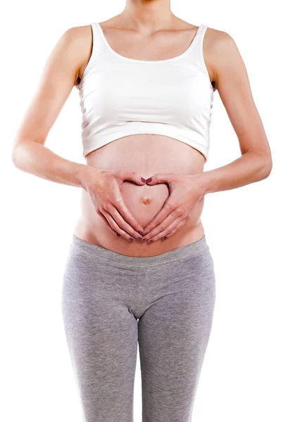 Mulher grávida segurando as mãos em forma de coração em seu bebê bu — Fotografia de Stock