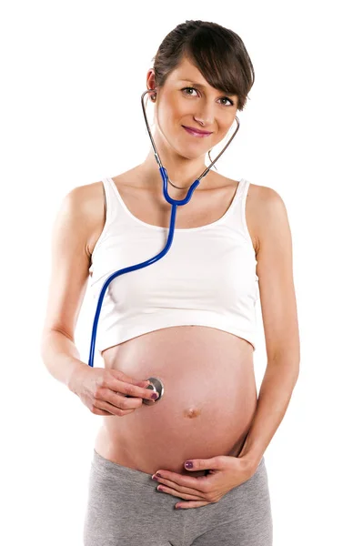 Pregnant woman listen with stethoscope her baby. Pregnant belly Stock Image