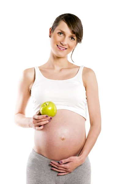 Kobieta w ciąży na białym tle nad białym tle, trzyma jabłko. — Zdjęcie stockowe