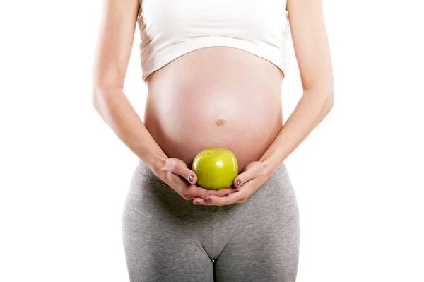 Mujer embarazada aislada sobre fondo blanco, sosteniendo manzana . — Foto de Stock