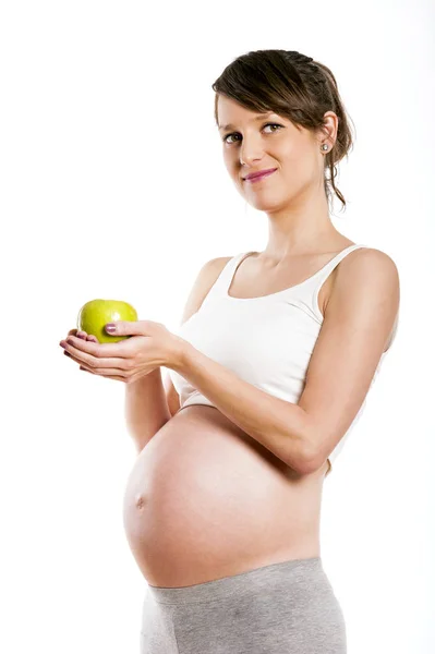 Mujer embarazada aislada sobre fondo blanco, sosteniendo manzana . — Foto de Stock