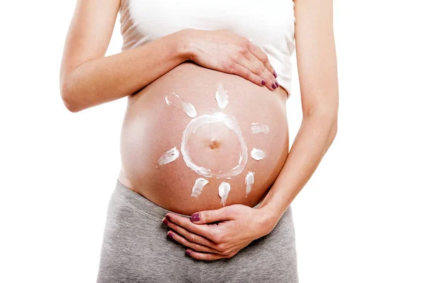 Gravid kvinna med grädde sol på magen, isolerade över vit rygg — Stockfoto