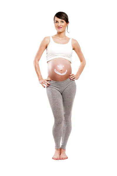 Mulher grávida com creme de sol na barriga, isolado sobre costas brancas — Fotografia de Stock