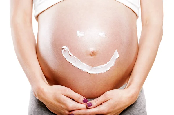 Крем щасливий смайлик обличчя на животі вагітної жінки ізольовані — стокове фото