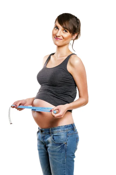 Mujer embarazada aislada sobre fondo blanco con centímetro . — Foto de Stock