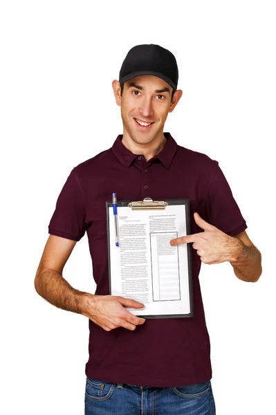 Smiling delivery man holding clipboard on white background point — Stock Photo, Image