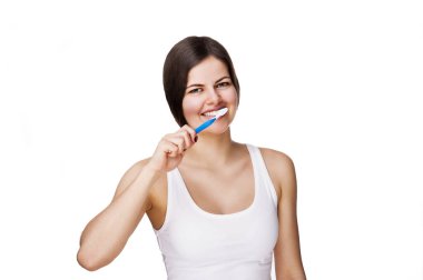 Sağlıklı dişleri olan gülümseyen genç bir kadın diş fırçası tutuyor.