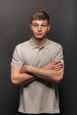 Adam gri polo t-shirt gülümseme ile siyah arka plan üzerine