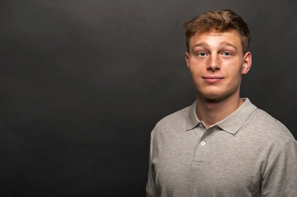 Camiseta de polo gris hombre sobre fondo negro con sonrisa —  Fotos de Stock