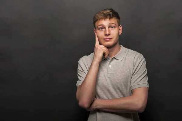 Man in de grijze polo t-shirt op zwarte achtergrond met glimlach — Stockfoto