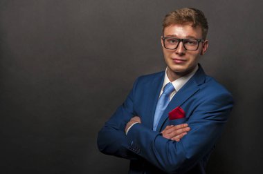 siyah elbiseli koyu arka plan üzerinde gülümseyen yakışıklı delikanlı