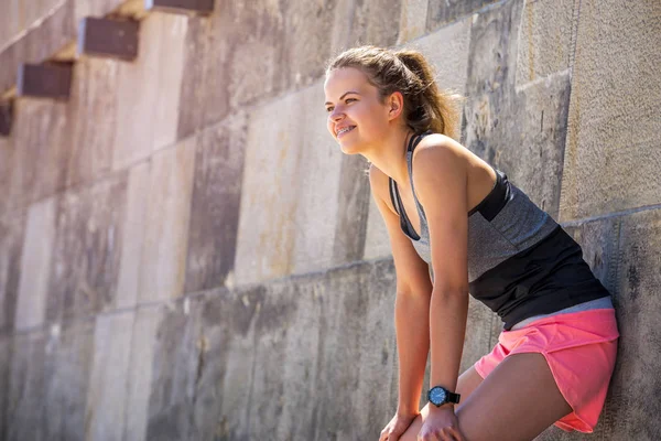 Joven mujer sonriente descansando después de un entrenamiento activo de fitness wh — Foto de Stock