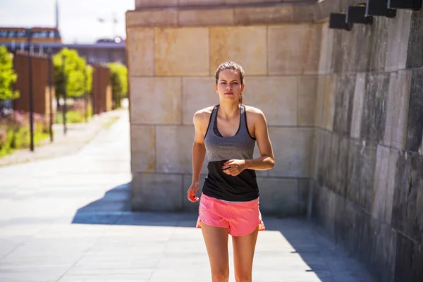 Sportovní mladá žena běží na chodníku v slunci. Zdravotní nevýhody — Stock fotografie