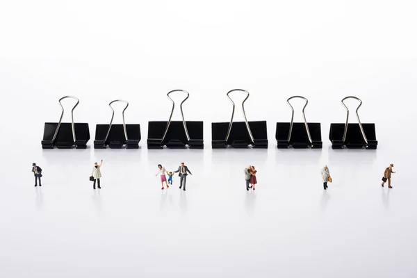 Linha de diversas pessoas minúsculas modelo miniatura e clipes em backgro — Fotografia de Stock