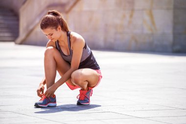 Koşu ayakkabıları - kadın ayakkabı bağcıklarımı bağlıyor. Kadın spor fitness çalıştırmak